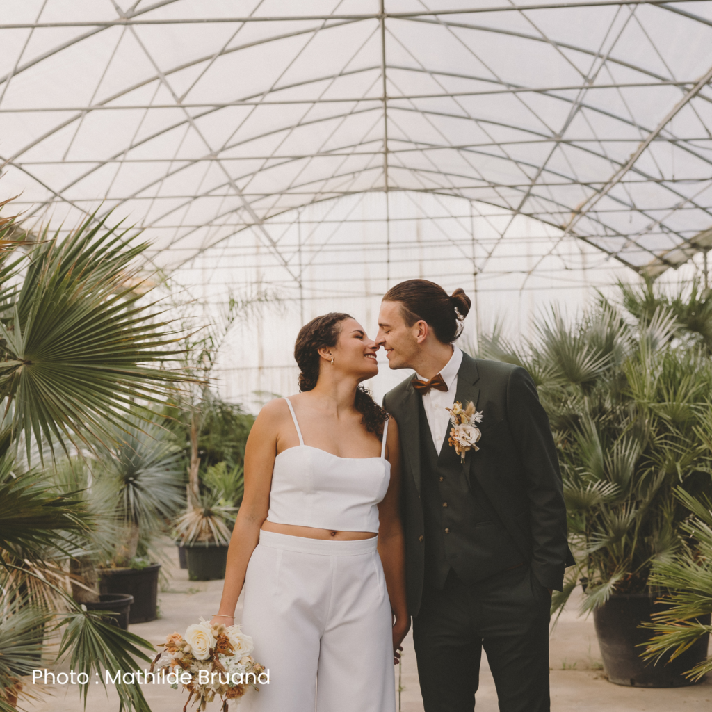 Mariés dans une serre à Vitré, Ille et Vilaine, mariée en crop top et pantalon, bouquet de fleurs fraiches à la main