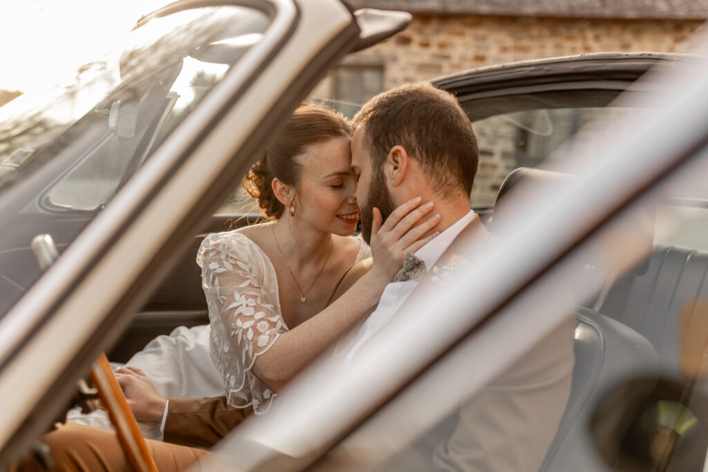 Jeunes mariés complices à bord d'une voiture ancienne, préparatifs de mariage sur 18 mois
